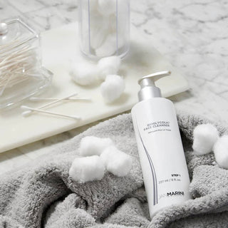 Jan Marini Bioglycolic Face Cleanser sitting on marble bathroom countertop. This product helps remove dirt and impurities from skin.